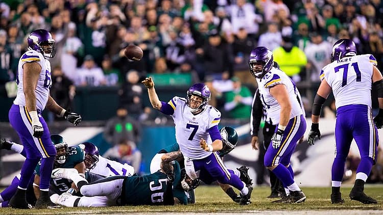 Vikings player in white jersey celebrates during game with teammates nearby.