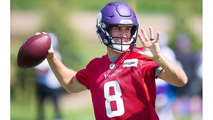 Vikings quarterback number 8 throws football during practice in red jersey.
