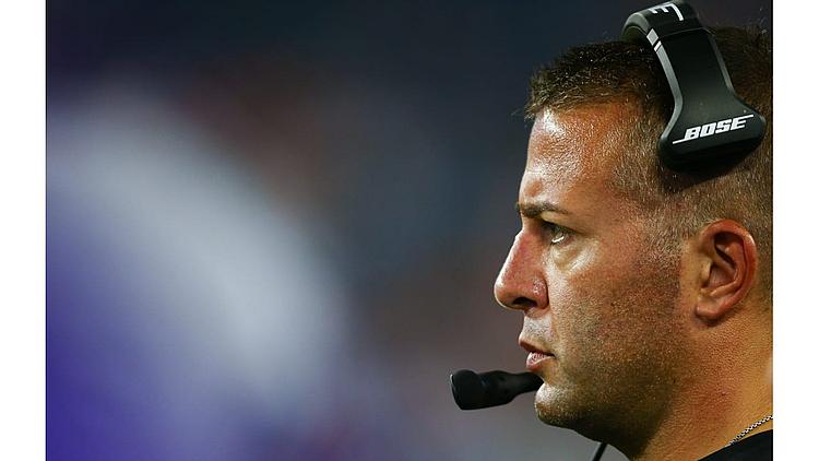 Coach wearing headset and microphone during game sideline.