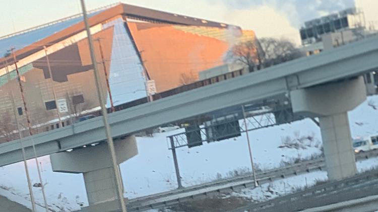 Highway overpass with yellow warning sign and industrial buildings visible.