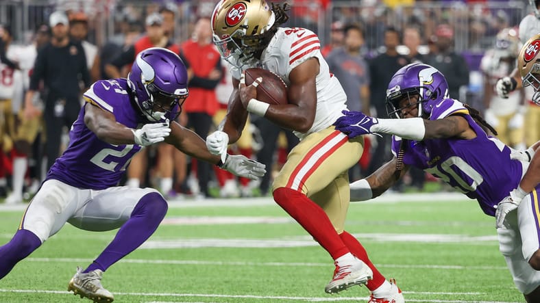 Minnesota Vikings cornerback Akayleb Evans defends 49ers running back Jordan Mason during a 2022 preseason game at U.S. Bank Stadium.