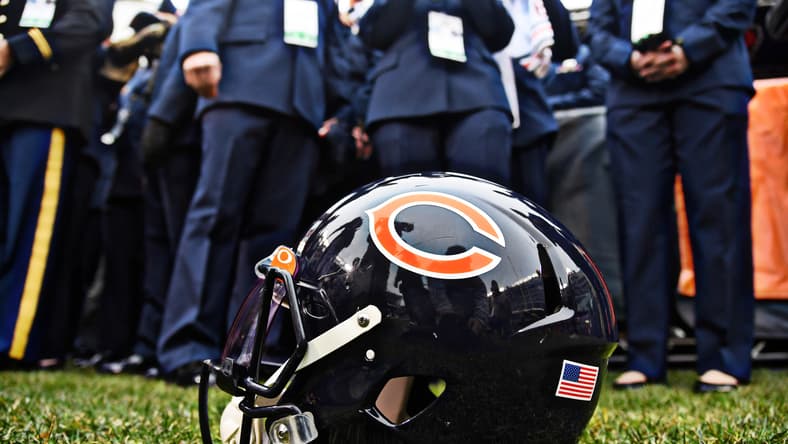 Close-up of a Chicago Bears helmet displaying the navy shell and orange logo before a game.