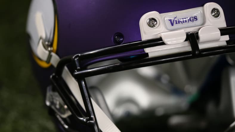 A Minnesota Vikings helmet sits on the turf before a game against the Packers at Lambeau Field.