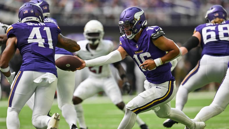 Jaren Hall hands the ball to Abram Smith during a preseason game against the Cardinals.