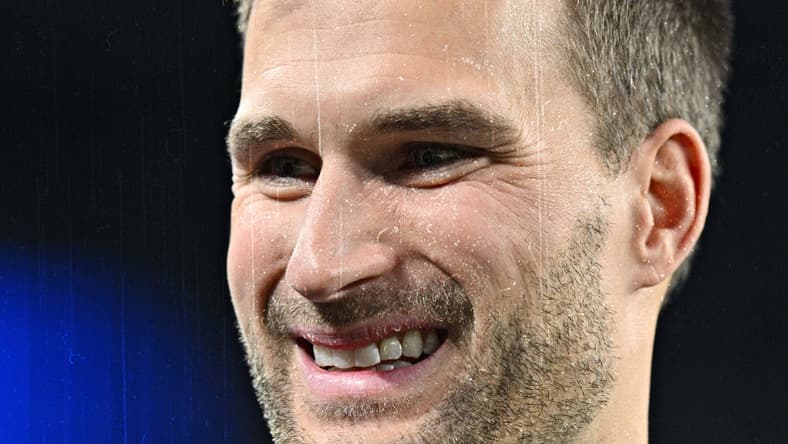 Kirk Cousins standing on the field before a Vikings game at U.S. Bank Stadium.