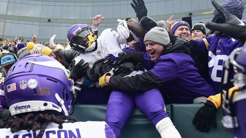 Jordan Addison celebrates with fans after scoring at Lambeau Field.