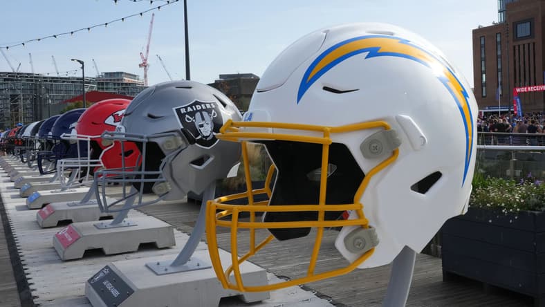 Oversized Chargers, Raiders, and Chiefs helmets displayed at NFL Experience London event at Battersea Power Station.