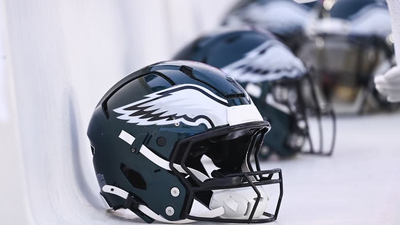 Philadelphia Eagles helmets lined up on the bench at Gillette Stadium.