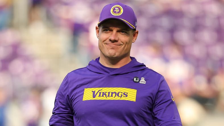 Kevin O’Connell standing on the sideline before a Vikings game at U.S. Bank Stadium.