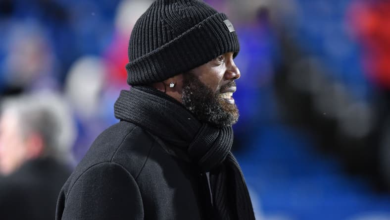 Randy Moss stands on the sideline before a Bills vs. Patriots game at Highmark Stadium.