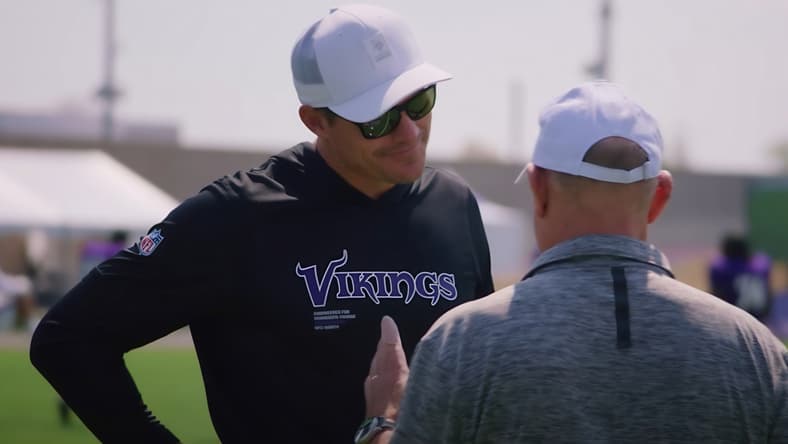 Kevin O’Connell talks with a coach during Vikings and Patriots joint practice at TCO Performance Center.