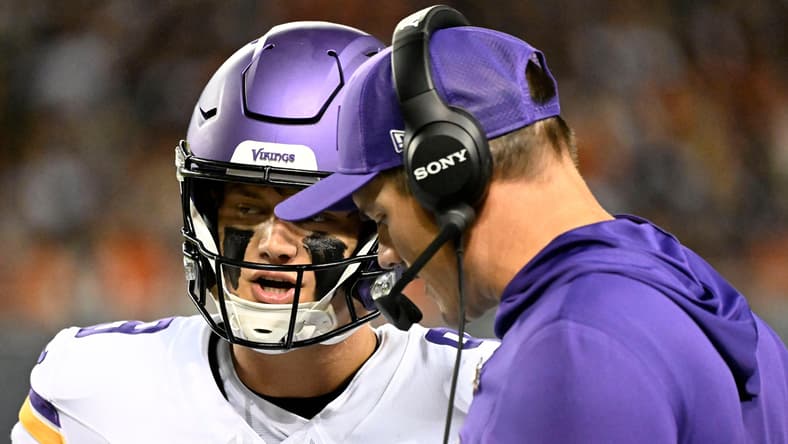 Kevin O’Connell speaks with J.J. McCarthy on the sideline during the first half at Soldier Field.