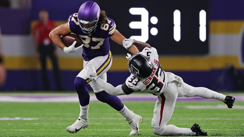 T.J. Hockenson runs after a catch against Falcons safety Billy Bowman Jr.