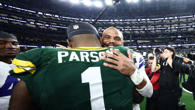 Micah Parsons and Dak Prescott embrace after a game at AT&T Stadium.
