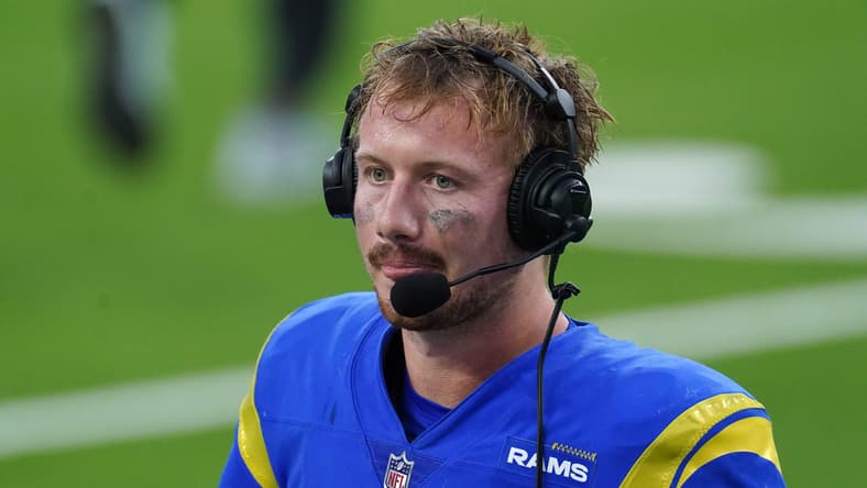 John Wolford wears headphones during a postgame interview at SoFi Stadium. former Vikings quarterbacks