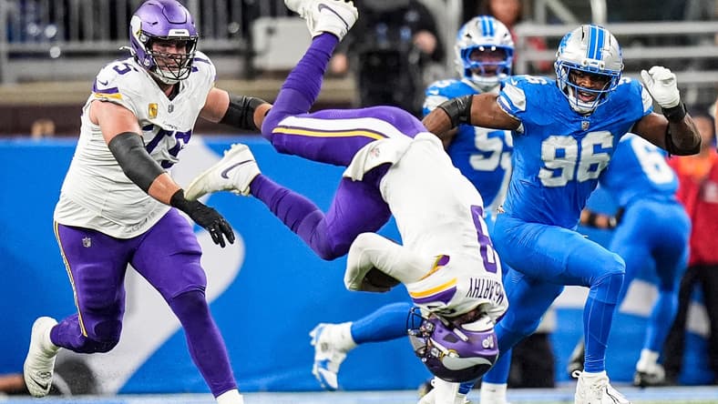 J.J. McCarthy flips after a tackle by Detroit’s Jack Campbell at Ford Field.