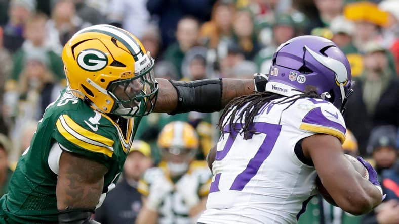 Vikings running back Jordan Mason carries the ball against Packers defender Micah Parsons at Lambeau Field.