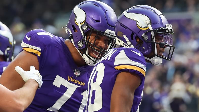 Christian Darrisaw, Justin Jefferson, and K.J. Osborn on the field during a Vikings–Packers game at U.S. Bank Stadium