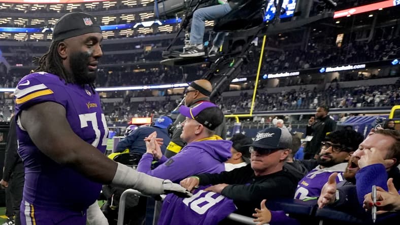 Bo Richter and Donovan Jackson celebrate with Minnesota Vikings fans after a game against the Dallas Cowboys.