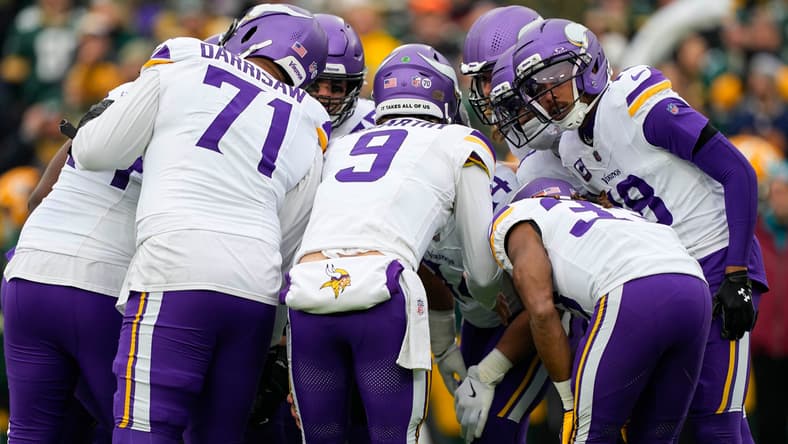 The Minnesota Vikings offense huddles during a game against the Green Bay Packers at Lambeau Field.