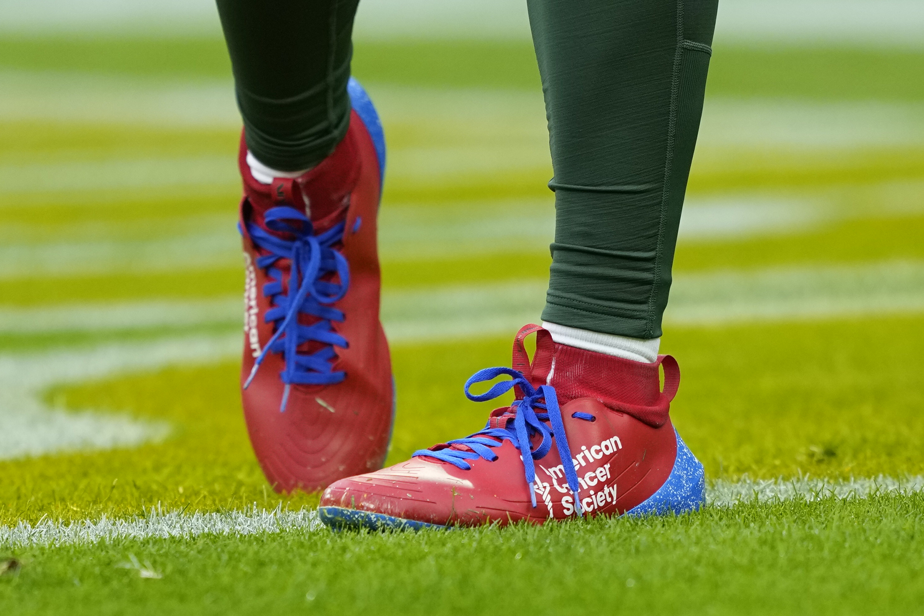 Malik Willis stands on the field before a Packers game at Lambeau Field.