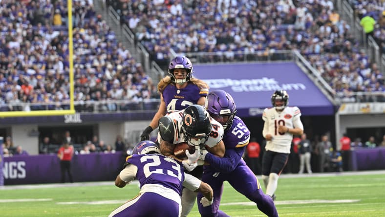 Colston Loveland is tackled by Fabian Moreau and Eric Wilson during a Bears–Vikings game at U.S. Bank Stadium.