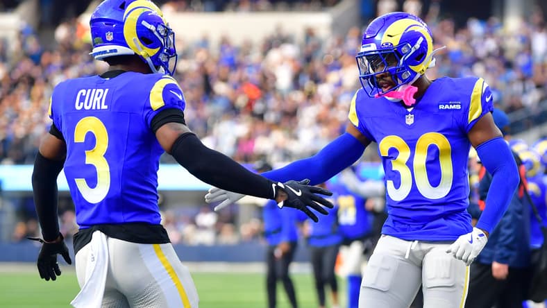 Rams defenders Kam Curl and Josh Wallace high-five after a play at SoFi Stadium.