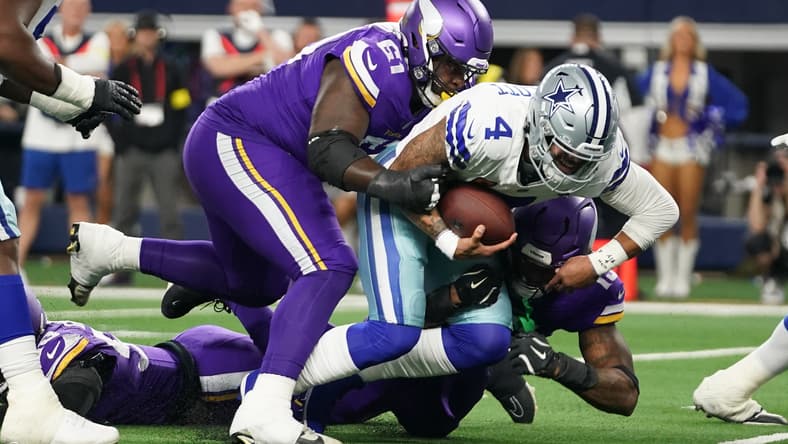 Jalen Redmond tackles Dak Prescott during a Vikings vs. Cowboys game at AT&T Stadium.