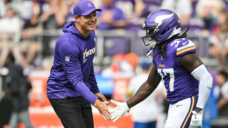 Kevin O'Connell speaks with Vikings cornerback Tavierre Thomas on the sideline before a preseason game against the Houston Texans.