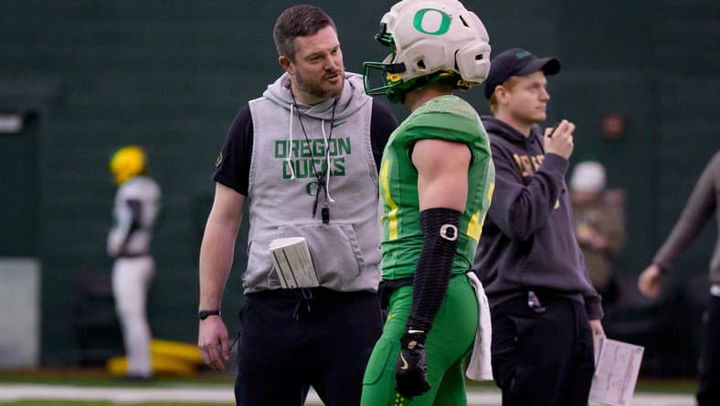 Dan Lanning talks with Oregon defensive back Dillon Thieneman during an Orange Bowl practice. Vikings theories