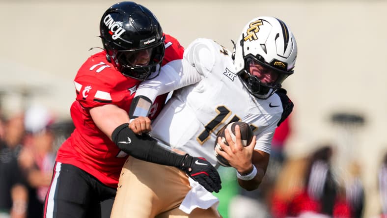 Jake Golday attempts to tackle UCF quarterback Cam Fancher during a game at Nippert Stadium.