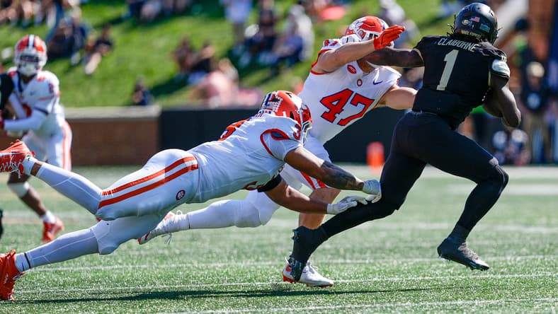 Demond Claiborne tries to avoid Clemson defenders during a game at Wake Forest.