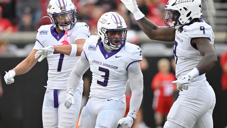 James Madison defenders celebrate together during a road game against Louisville.