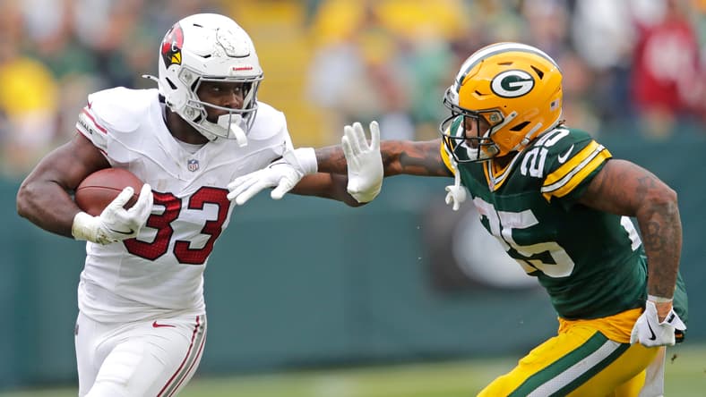 Trey Benson runs for a first down against the Green Bay Packers at Lambeau Field.