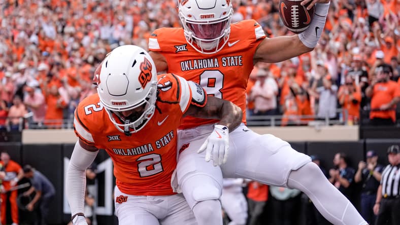 Oklahoma State quarterback Hauss Hejny celebrates a touchdown with receiver Terrill Davis against UT Martin.