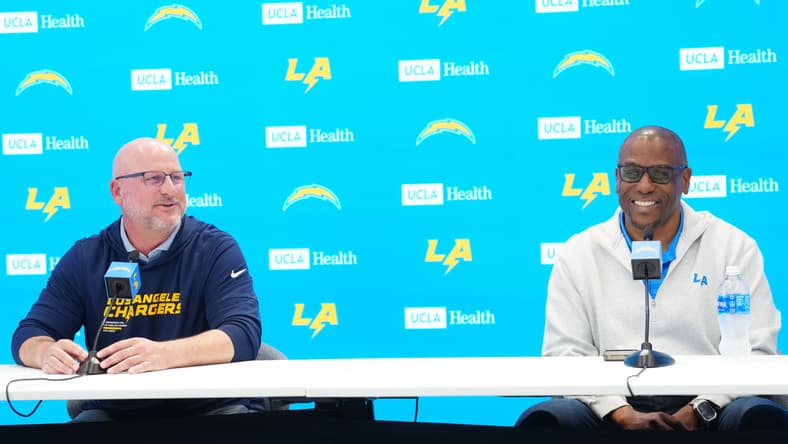 Chargers general manager Joe Hortiz speaks with assistant general manager Chad Alexander during a press conference.