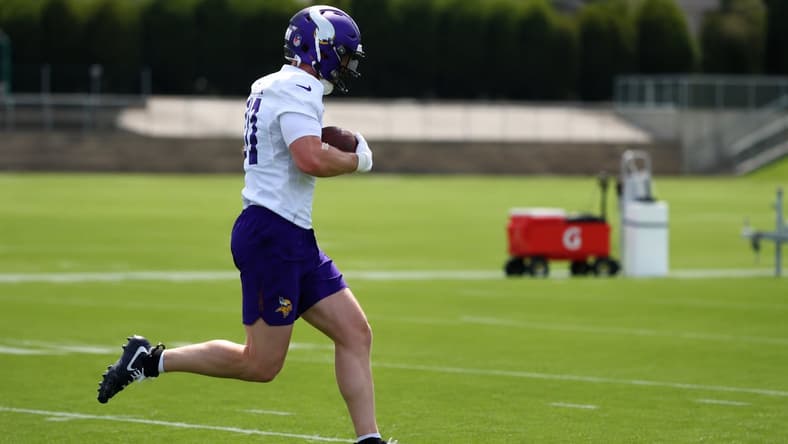 Jake Golday carries the football during Vikings minicamp practice in Eagan.