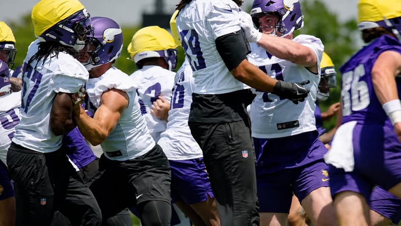 Jake Golday practices with Vikings defenders during OTAs in Eagan.