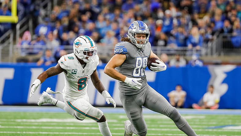 T.J. Hockenson running with the ball against a Dolphins defender at Ford Field. T.J. Hockenson Lions Rumor.