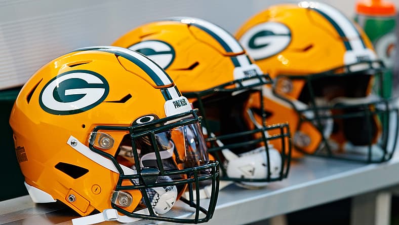 Green Bay Packers helmets lined up on the sideline at Lambeau Field