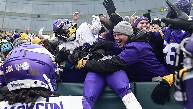 Jordan Addison celebrates with fans after scoring at Lambeau Field.