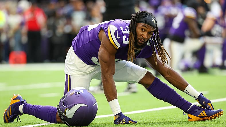 Aaron Jones of the Minnesota Vikings stretches on the field before a home game against the Lions.