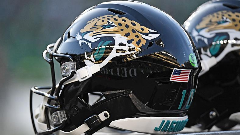 Football helmets with jaguar logo and American flag displayed side by side