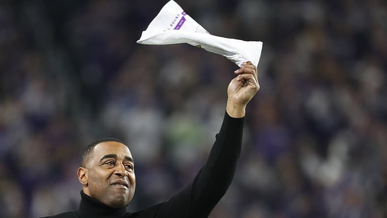 Cris Carter waves a towel on the sideline during a Vikings playoff game.