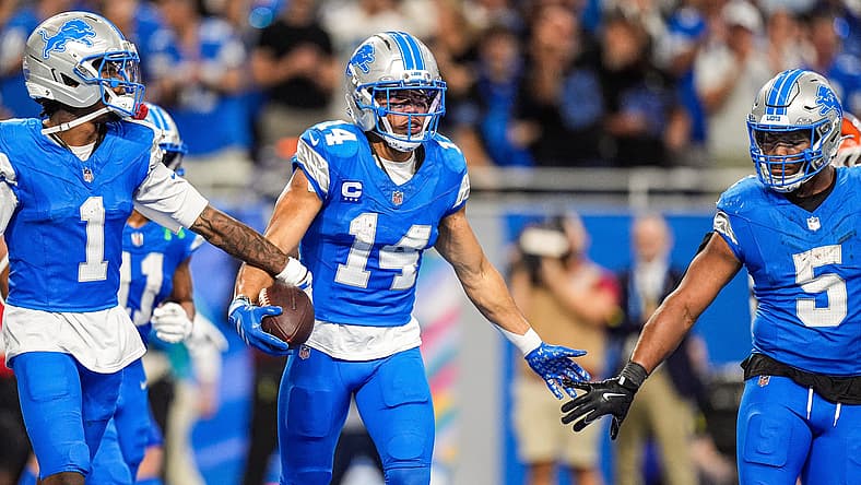 Amon-Ra St. Brown celebrates a touchdown with Jameson Williams and David Montgomery during a Lions game against the Browns. NFC North predictions