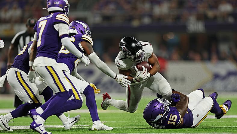 Dallas Turner tackling Bijan Robinson at U.S. Bank Stadium.