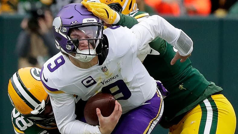 Isaiah McDuffie and Warren Brinson sack J.J. McCarthy at Lambeau Field.