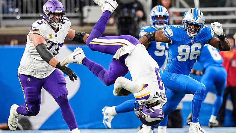 J.J. McCarthy flips after a tackle by Detroit’s Jack Campbell at Ford Field.