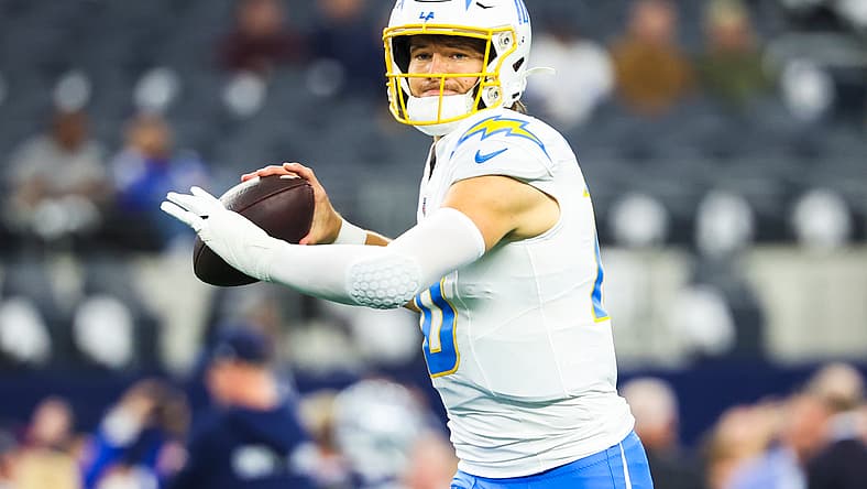 Justin Herbert warms up on the field before a Chargers game at AT&T Stadium.