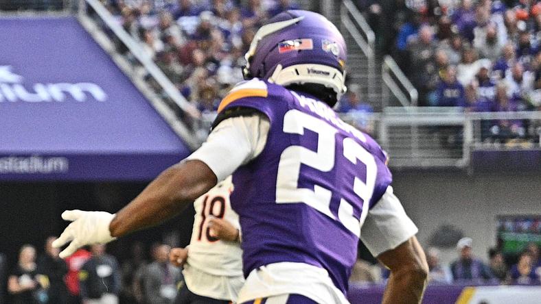 Colston Loveland runs after a catch as Fabian Moreau defends during a game at U.S. Bank Stadium.
